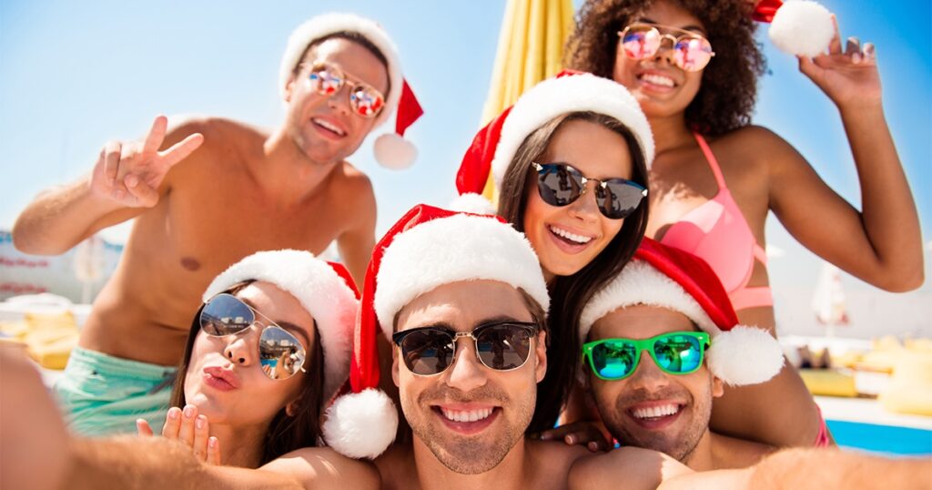 Group of charter yacht guests in Santa hats in the Caribbean sunshine
