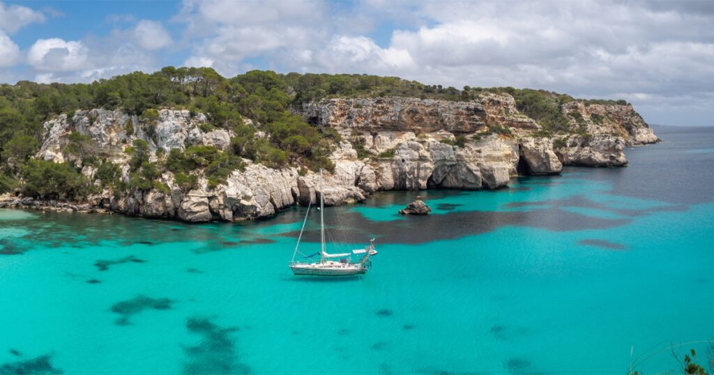 A charter yacht moored in the crystal clear waters of Menorca in the Balearic Islands