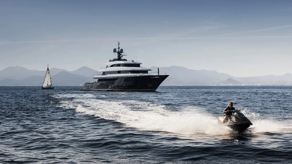 Charter guest using a jet ski with Motor Yacht Loon in the background