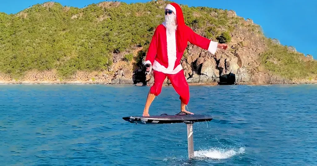 Superyacht crew member from Motor Yacht Loon dressed as santa on an efoil